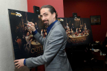 Composer Bear McCreary signs a poster at the Outlander: From Scotland to Paris event, April 5, 2016, at the NYU Skirball Center for the Performing Arts in New York City.